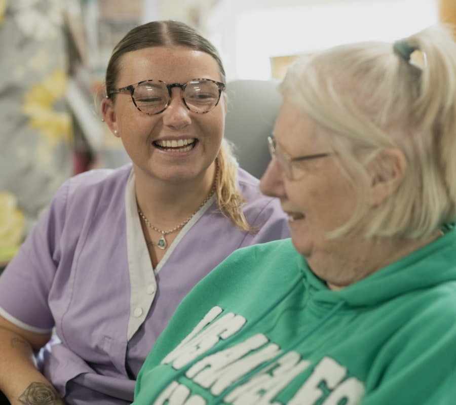 Two people laughing together during a support visit